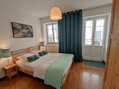 克莱尔沃雷拉克Villas du Lac的一间卧室配有一张带绿色窗帘的大床