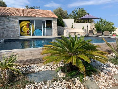 巴斯蒂亚Magnifique maison avec vue mer hauteur de Bastia的一座房子旁的游泳池,里面种着棕榈树