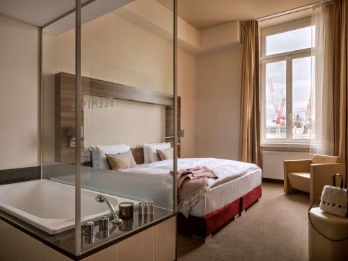维也纳Flemings Selection Hotel Wien-City的酒店客房配有一张床和浴缸。