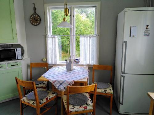 HenånLägenhet naturnära i Henån的厨房配有桌椅和冰箱。