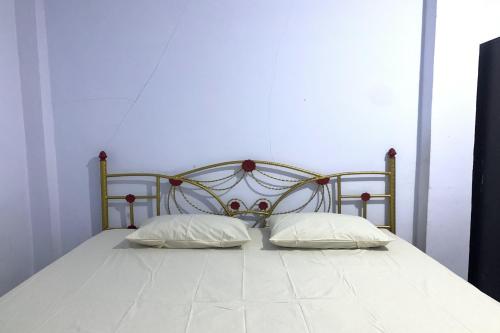 特尔纳特岛OYO 92892 Aini Homestay的一张床上有两个枕头的房间