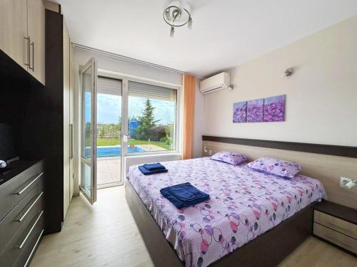 卡瓦尔纳Golf Villa Ariel的一间卧室配有一张带紫色床单的床和窗户。