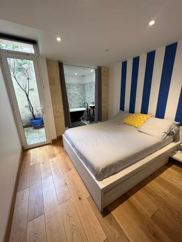 波尔多Appartement 2 chambres climatisé triangle d’or的一间卧室配有一张蓝色和白色条纹的床
