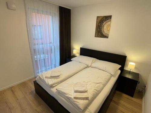 斯维特Apartmán Gréner的一间卧室配有一张带白色床单的大床