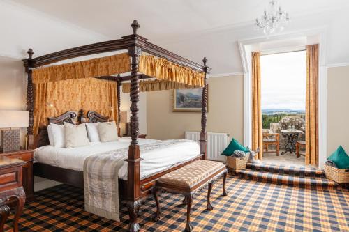 丁沃尔塔洛克城堡酒店“定制酒店”的一间卧室设有四柱床和窗户。