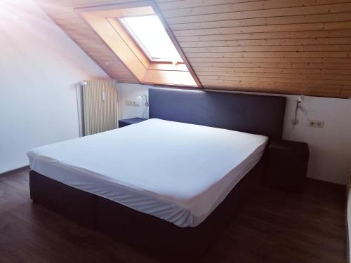 霍恩贝格Haus Schwarzwaldblick的卧室配有一张白色大床和天窗
