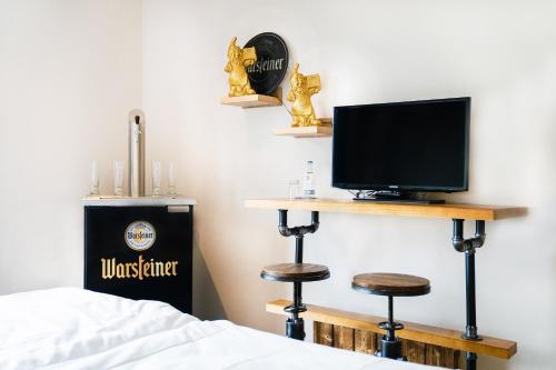 布伦AiREA Hotel的一间卧室配有一张床、一台电视和一张书桌