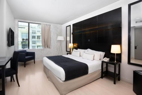 布宜诺斯艾利斯解放者城市酒店的酒店客房设有一张大床和一张书桌。