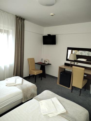 大谢尔皮亚Hotel Eljot的酒店客房设有两张床、一张书桌和一架钢琴。
