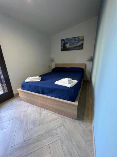 利卡塔Benvenuti al Sud B&B的一间卧室配有一张蓝色床单,铺有木地板