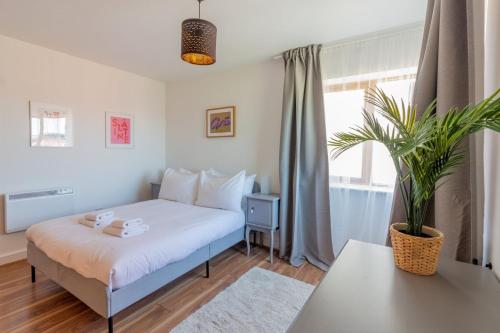 都柏林GuestReady - Modern stay by Pheonix Park的一间卧室配有一张床和盆栽植物