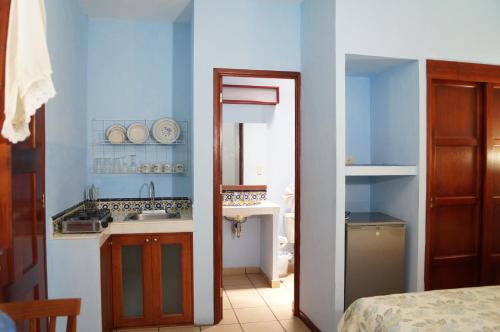瓦哈卡市Las Mariposas Hotel & Studios的蓝色的厨房设有水槽和镜子