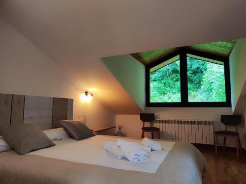 坎普罗东Allotjaments el Pont的卧室配有一张大白色床和窗户