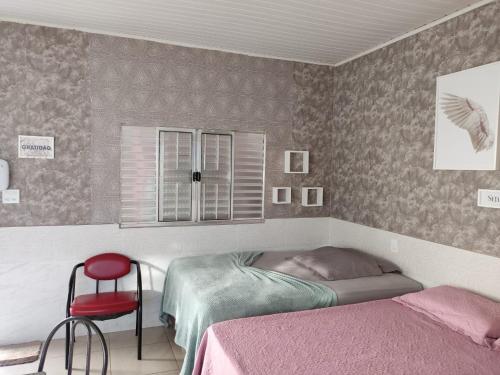 里约布兰科Condomínio DINASEG的一间卧室配有两张床和红色椅子