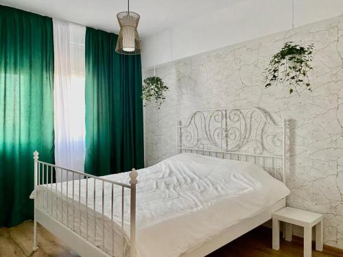 蒂米什瓦拉Union Experience - City Center的卧室内的白色婴儿床,配有绿色窗帘