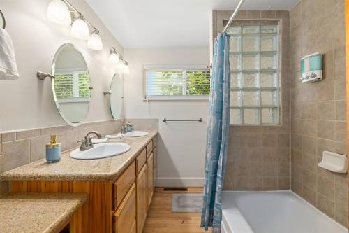 博伊西1950s Charmer的浴室配有2个盥洗盆、浴缸和淋浴。