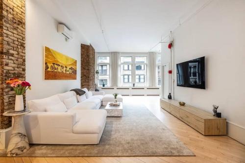 纽约Luxurious 2 Bedroom Loft Entire Apartment的客厅配有白色家具和砖墙