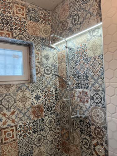 萨拉热窝Davud Apartments的浴室的墙壁上设有瓷砖和淋浴。