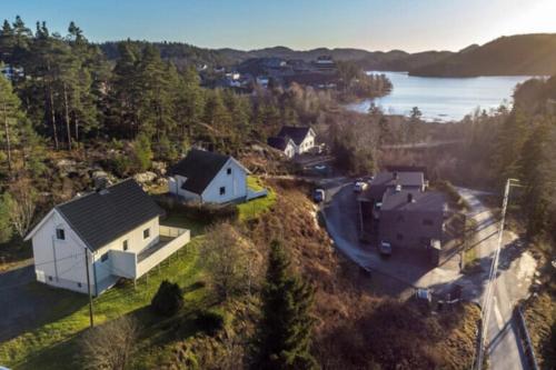 弗洛兰德维尔克Hytte Sørlandet med spa的享有湖畔山丘上房屋的空中景致