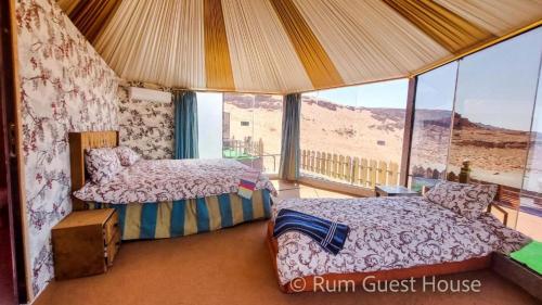 亚喀巴wadi rum guest house camp的一间设有两张床的卧室,享有沙漠美景