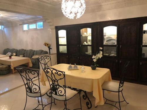 阿加迪尔Villa piscine Agadir的一间带2张桌子和椅子的用餐室以及吊灯