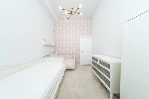 纽约Furnished and Meticulously Renovated 3-bedroom, 2-bathroom Loft的卧室配有白色家具和粉红色的墙壁