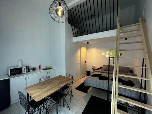 克卢日-纳波卡Vila Ana 2 Untold的一间带一张床和一张餐桌的房间和一个阁楼