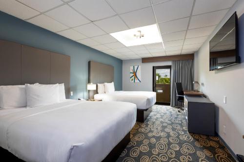 迈阿密Regency Miami Airport by Sonesta的酒店客房设有两张床和电视。