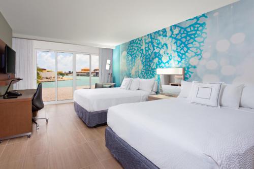 克拉伦代克Courtyard by Marriott Bonaire Dive Resort的酒店客房设有两张床和电视。