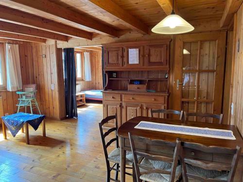 法伊多Appartamento accogliente di montagna a Cavagnago的小屋内带桌椅的用餐室