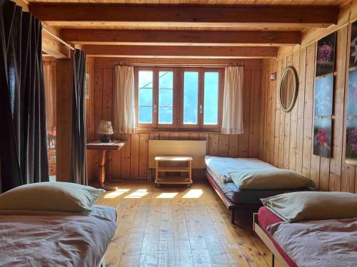 法伊多Appartamento accogliente di montagna a Cavagnago的带三张床和窗户的客房