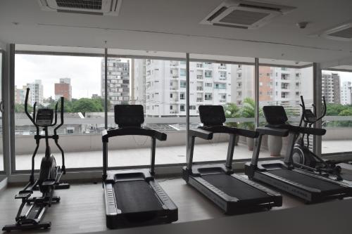 巴兰基亚Apartaestudio DISTRITO 90的一间健身房,在大窗户前设有四台跑步机