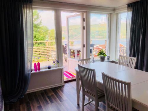 SvenshögenLovely holiday house by a beautiful lake!的一间带桌椅和窗户的用餐室