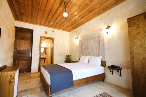 格雷梅Rocca Stone House的一间卧室设有一张床和木制天花板