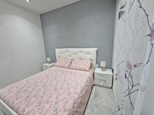 马达莱纳La Maddalena Holiday Home的一间卧室配有粉红色的床和2个床头柜