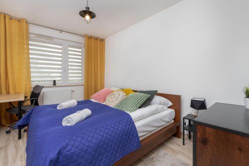 格但斯克Apartment Przytulna Kiełpinek by Renters的一间卧室配有一张带蓝色棉被的床