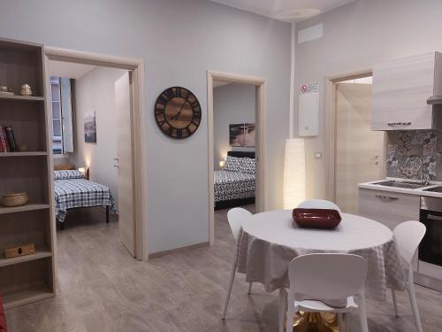 萨沃纳Appartamento Piazzetta La Maddalena的厨房以及带桌子和时钟的用餐室。