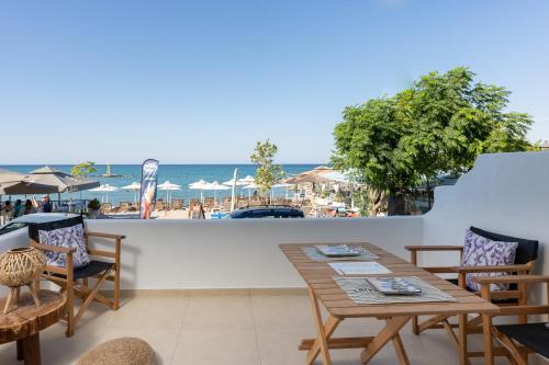 帕拉塔蒙Galazio Seaside Luxury Rooms & Coffee Shop的一个带桌椅的庭院和海滩