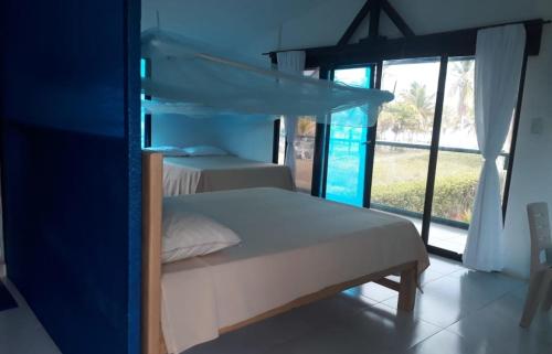 MoñitosCabaña RECUERDO Lodge, B & B的一间卧室设有两张床和大窗户