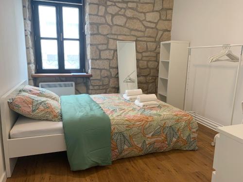 阿尔泽特河畔埃施Private Room in the City Centre的一间卧室设有一张床和石墙