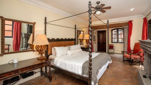 圣米格尔-德阿连德Centro 3BR Home Steps to La Parroquia的一间卧室设有一张天蓬床和一个壁炉