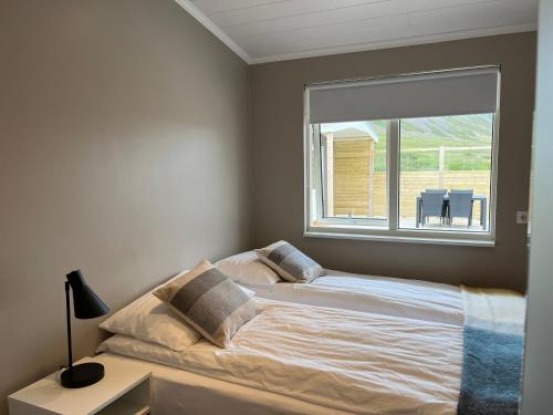 Birkimelur Strönd Guesthouse的卧室内的一张床铺,设有大窗户