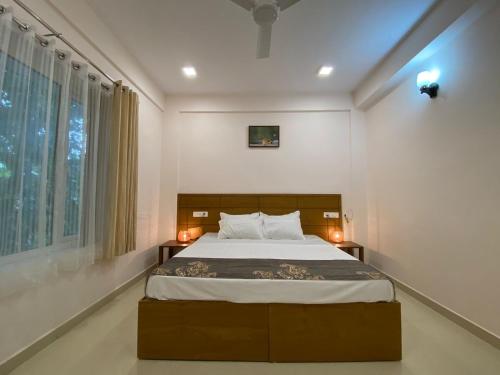 安加马尔伊Daffodils Luxury Airport Suites的一间卧室设有一张大床和一个窗户。