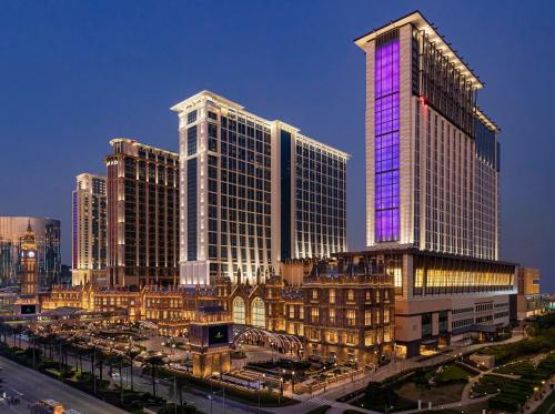 澳门澳门喜来登大酒店的城市里一座高大的建筑,上面有紫色的灯光