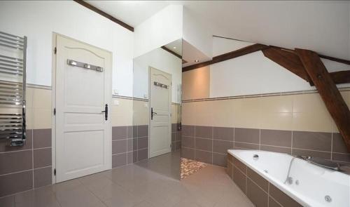 SambinMAISON DE CARACTERE COSY的一间设有白色门和浴缸的大浴室