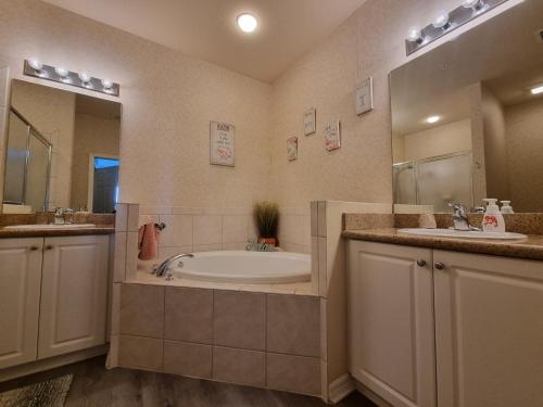 那不勒斯Greenlinks 923 at Lely Resort - Luxury 2 Bedrooms & Den Condo的浴室配有两个盥洗盆和浴缸。