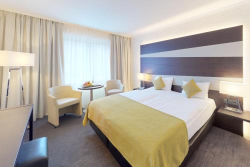 卢森堡阿尔维斯帕克酒店的酒店客房设有一张大床和一张桌子。