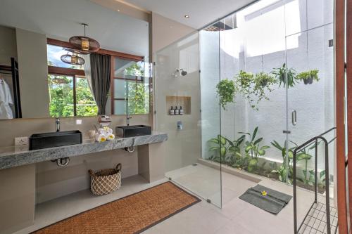 乌布The Studios Ubud的一间带两个水槽和玻璃淋浴间的浴室