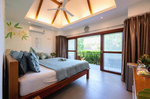 拉迈ORCHID LODGE SAMUI - Bed & Breakfast的一间卧室配有一张带吊扇的床