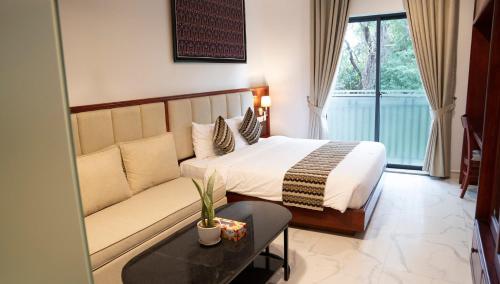 暹粒Marvelinn Siem Reap的酒店客房,配有床和沙发